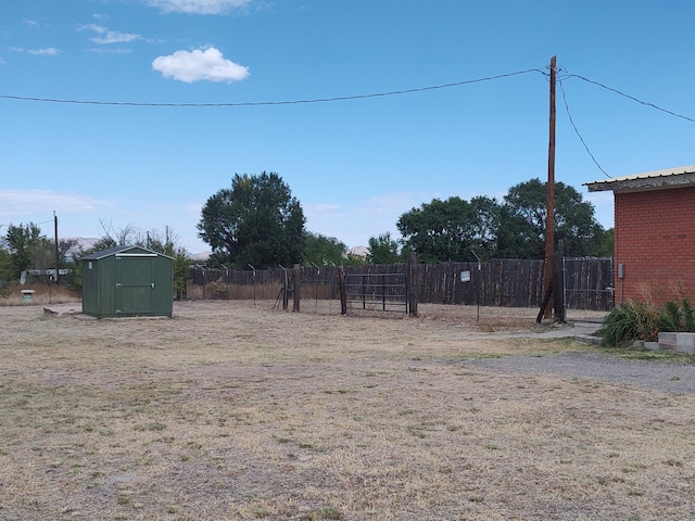 view of yard with an outbuilding, a storage shed, and fence