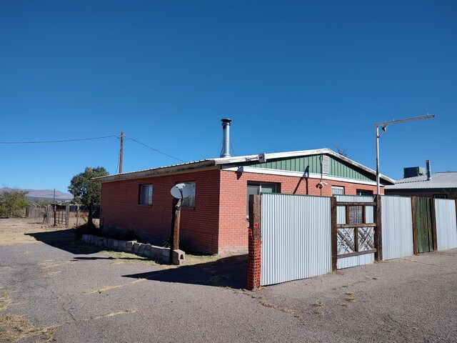 view of side of home featuring fence and brick siding