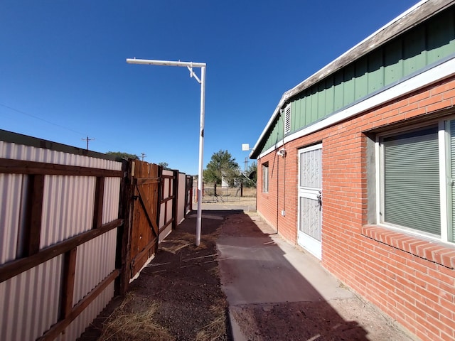 view of home's exterior with fence, brick siding, and board and batten siding