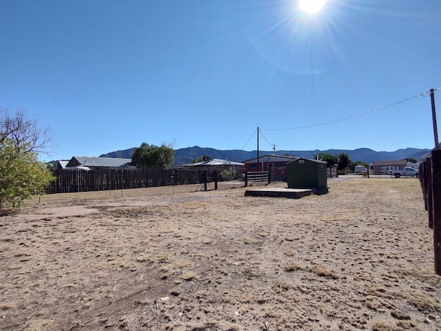 view of yard featuring a mountain view and fence