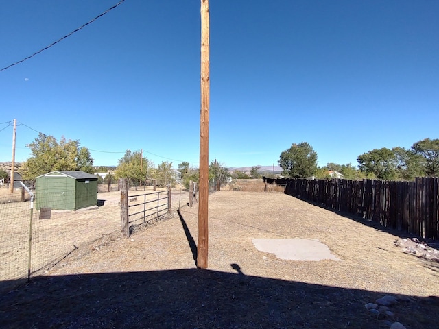 view of yard featuring a storage unit, an outdoor structure, and a fenced backyard