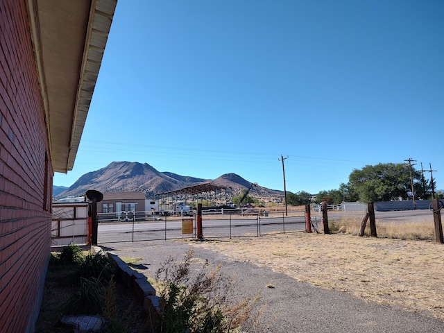 exterior space with a gate, a mountain view, and driveway