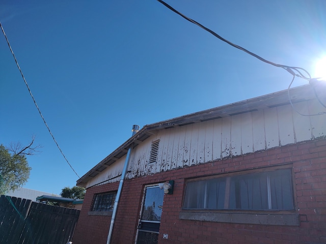 view of home's exterior with brick siding and fence