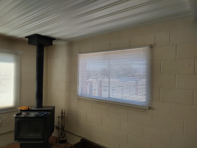 interior details with concrete block wall and a wood stove