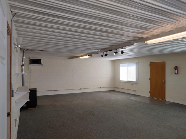 basement with a wall mounted air conditioner and concrete block wall