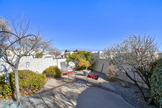 view of patio / terrace featuring a fenced backyard and a mountain view