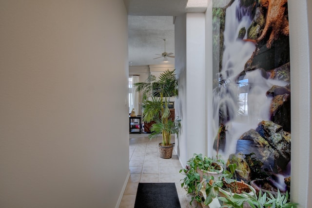 hallway featuring baseboards and light tile patterned flooring