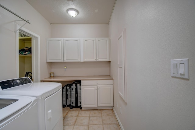 clothes washing area with cabinet space, separate washer and dryer, a textured ceiling, and light tile patterned flooring