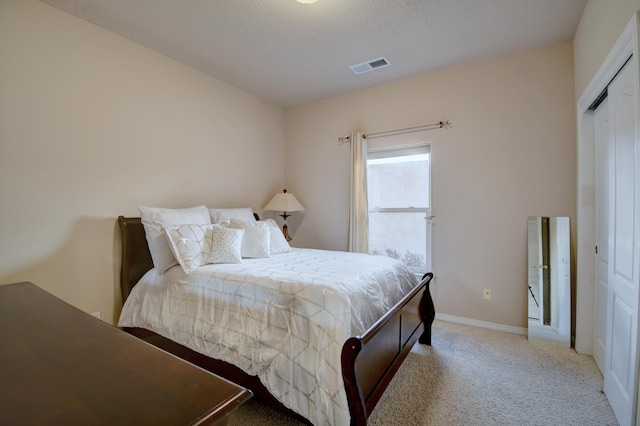 bedroom featuring baseboards, visible vents, and light colored carpet