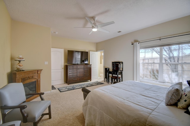 bedroom featuring a ceiling fan, carpet flooring, visible vents, and a textured ceiling