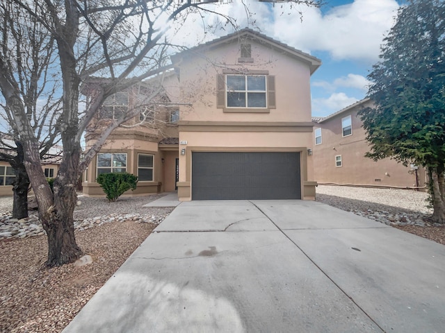 traditional-style home featuring driveway, a garage, and stucco siding