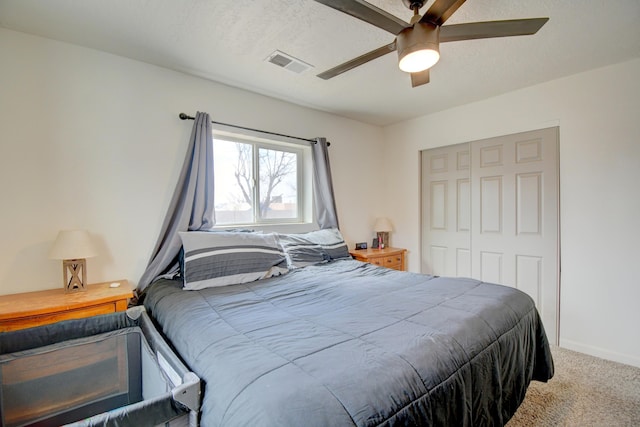 carpeted bedroom with a ceiling fan, a closet, visible vents, and baseboards