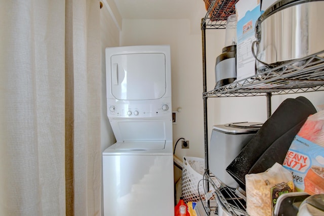 laundry area featuring stacked washer / drying machine and laundry area