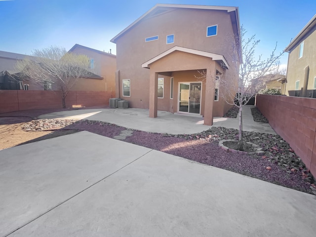 rear view of house featuring central air condition unit, a fenced backyard, a patio, and stucco siding