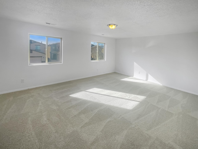 carpeted empty room with a textured ceiling