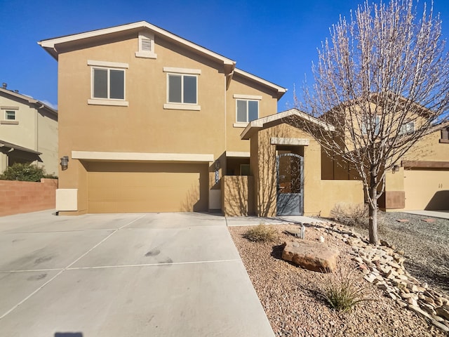 view of front facade with driveway, an attached garage, and stucco siding