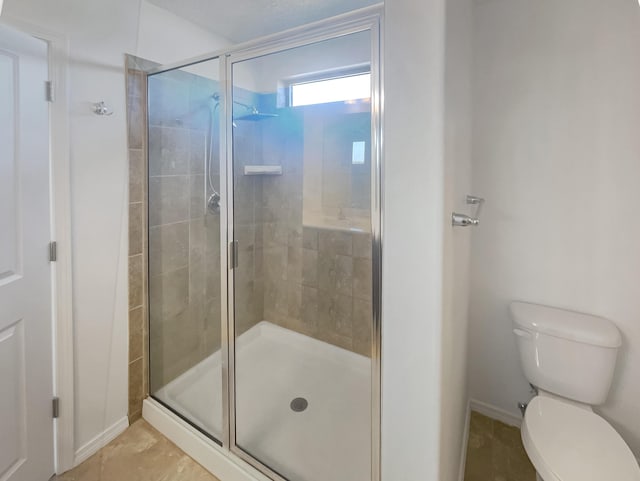 bathroom featuring a shower stall and toilet