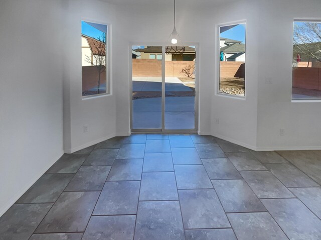 interior space featuring a wealth of natural light, tile patterned flooring, and baseboards