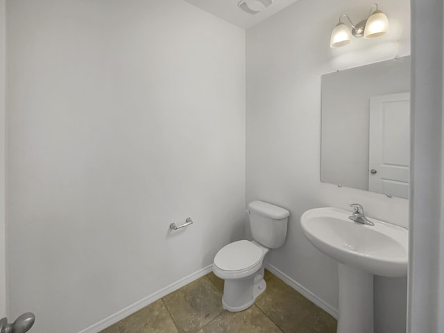 half bath with toilet and baseboards