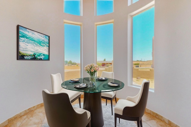 dining room with light tile patterned floors, plenty of natural light, and baseboards