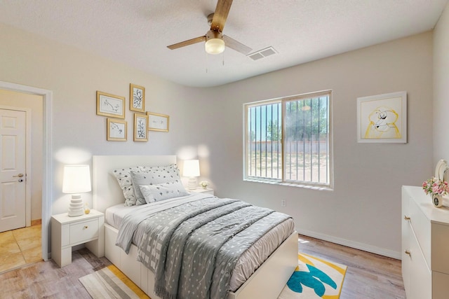 bedroom featuring a textured ceiling, light wood finished floors, and visible vents