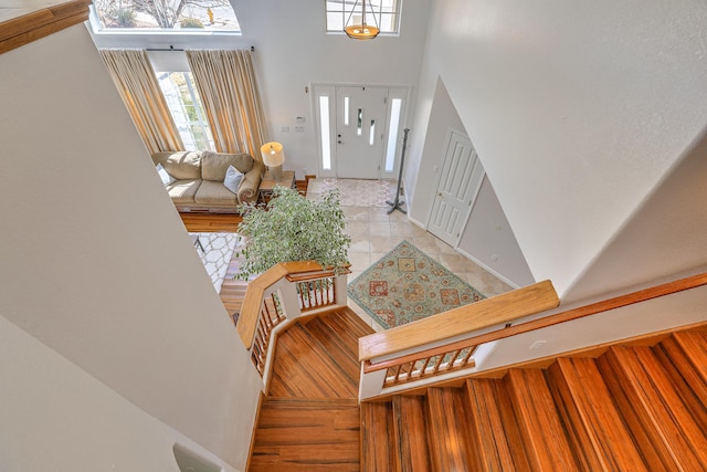 foyer featuring light tile patterned floors, a high ceiling, and baseboards