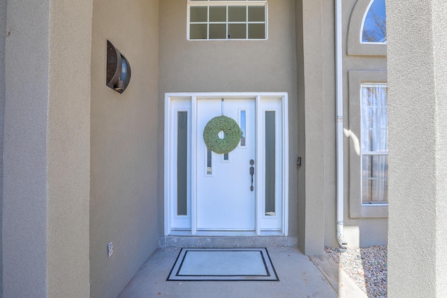 doorway to property featuring stucco siding