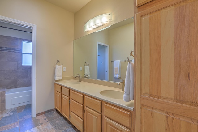 bathroom featuring stone finish flooring, a sink, and double vanity