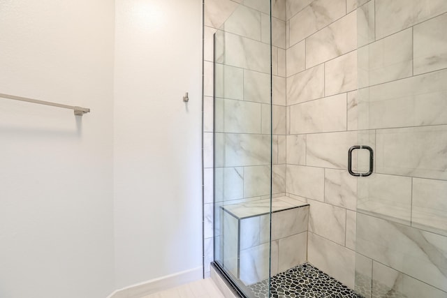 full bath featuring a stall shower and baseboards