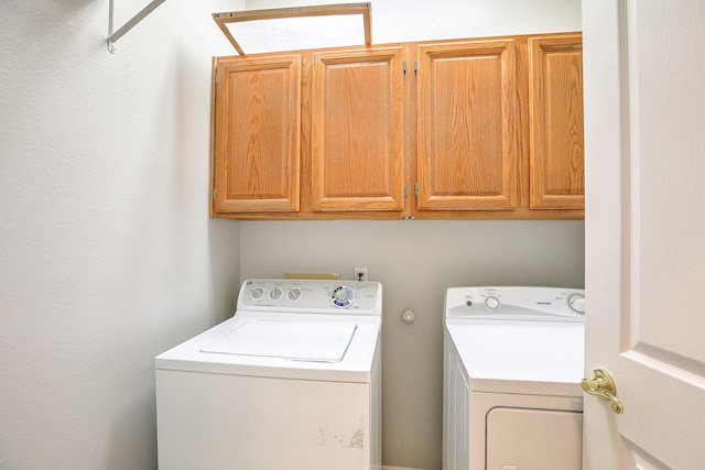 laundry room featuring independent washer and dryer and cabinet space