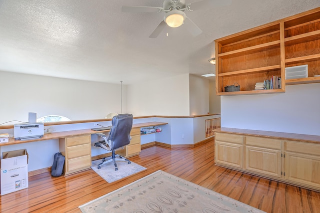 office with a textured ceiling, ceiling fan, light wood-type flooring, and baseboards