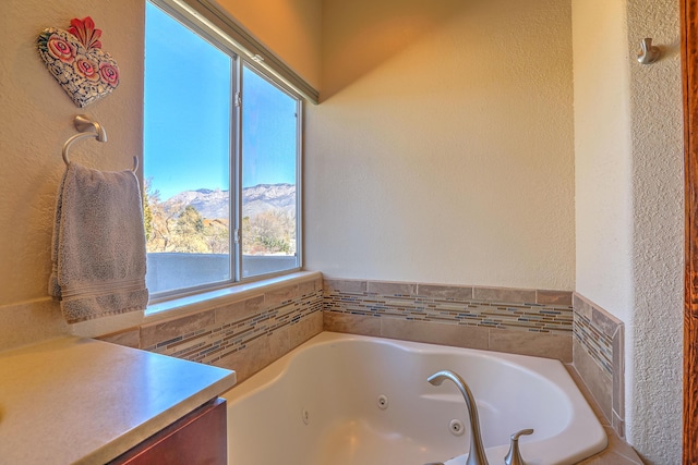 full bath with a jetted tub and a mountain view