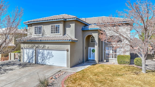 mediterranean / spanish-style home with stucco siding, concrete driveway, a garage, a tiled roof, and a front lawn