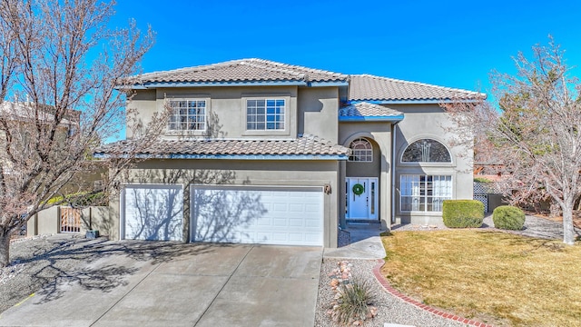 mediterranean / spanish-style home featuring a front yard, a tiled roof, and stucco siding