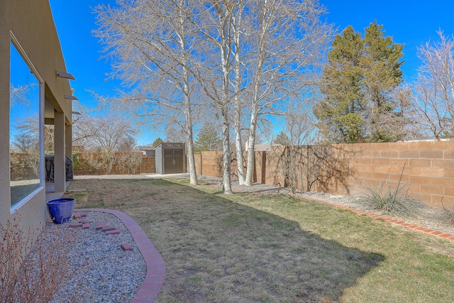 view of yard featuring a storage shed, an outdoor structure, and a fenced backyard