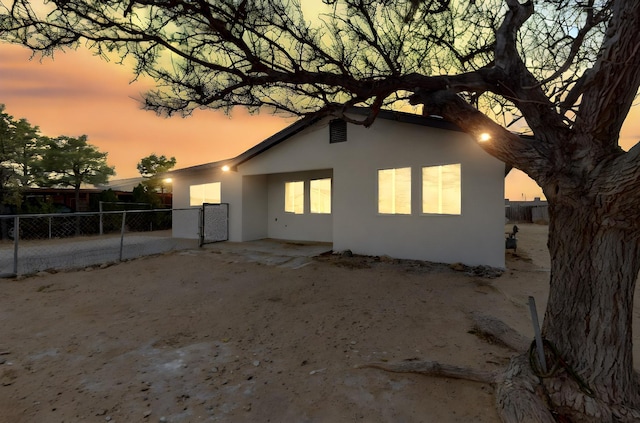 back of house featuring stucco siding and fence