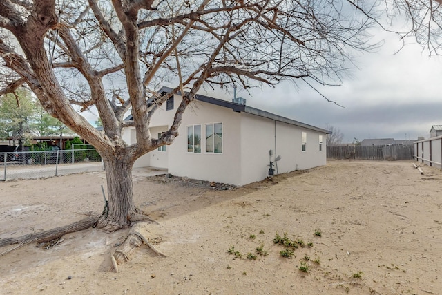 view of side of home featuring stucco siding and a fenced backyard