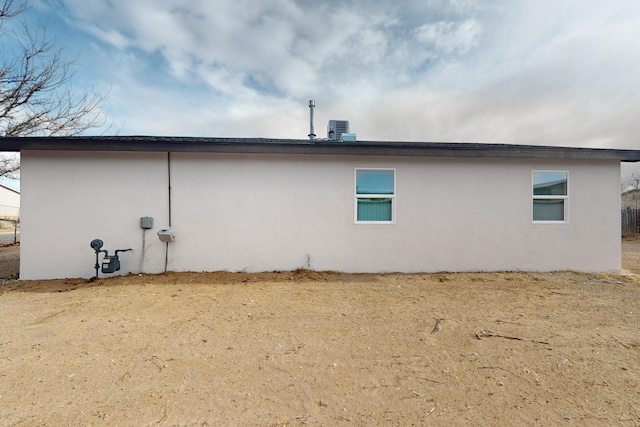 view of property exterior with stucco siding and central air condition unit