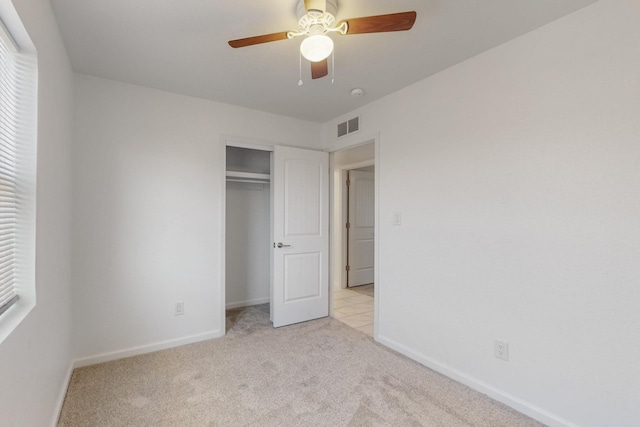 unfurnished bedroom featuring a closet, visible vents, light colored carpet, and baseboards