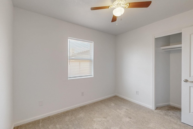 unfurnished bedroom with a closet, light carpet, baseboards, and ceiling fan