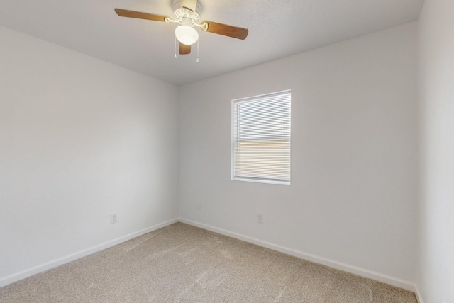 unfurnished room with baseboards, light colored carpet, and a ceiling fan