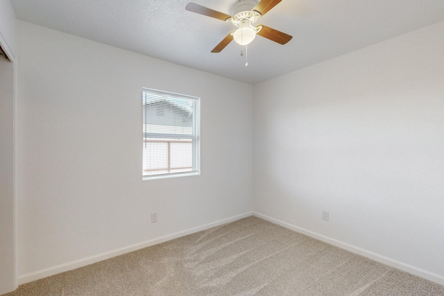 unfurnished room featuring light colored carpet, baseboards, and ceiling fan