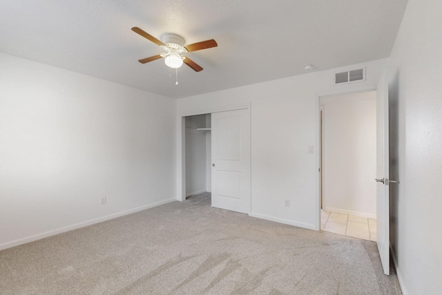 unfurnished bedroom featuring a ceiling fan, visible vents, baseboards, a closet, and carpet flooring