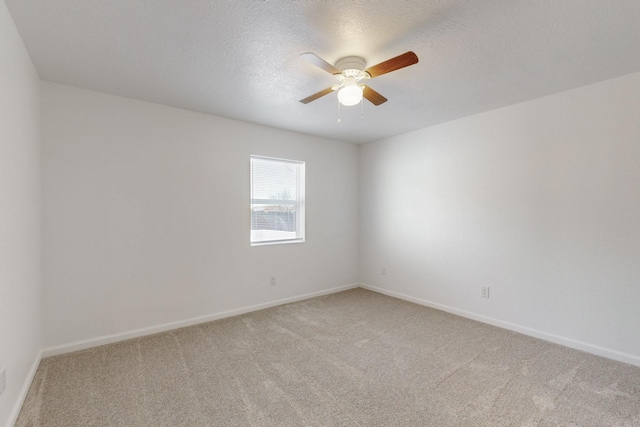 carpeted spare room with baseboards, a textured ceiling, and ceiling fan