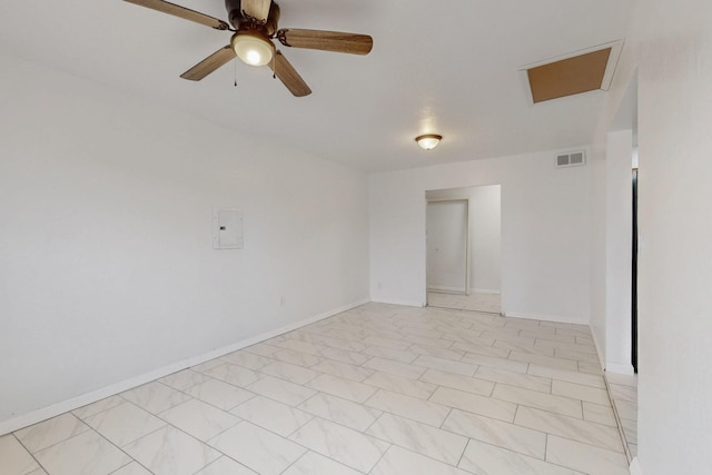 spare room with visible vents, baseboards, attic access, and a ceiling fan