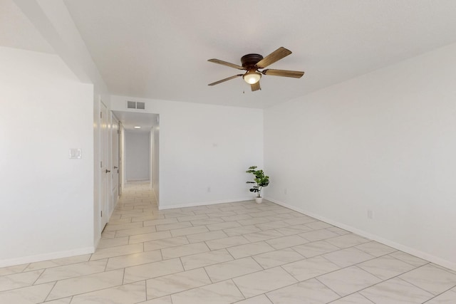 spare room with a ceiling fan, visible vents, and baseboards