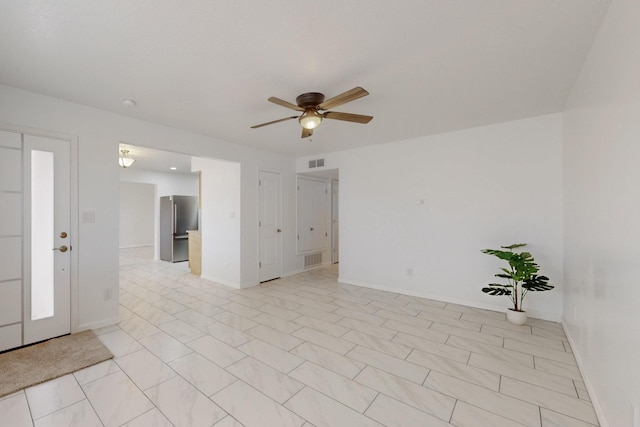 empty room featuring baseboards, visible vents, and ceiling fan