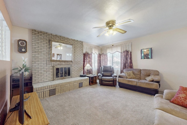 living area featuring ceiling fan, a fireplace, and carpet flooring