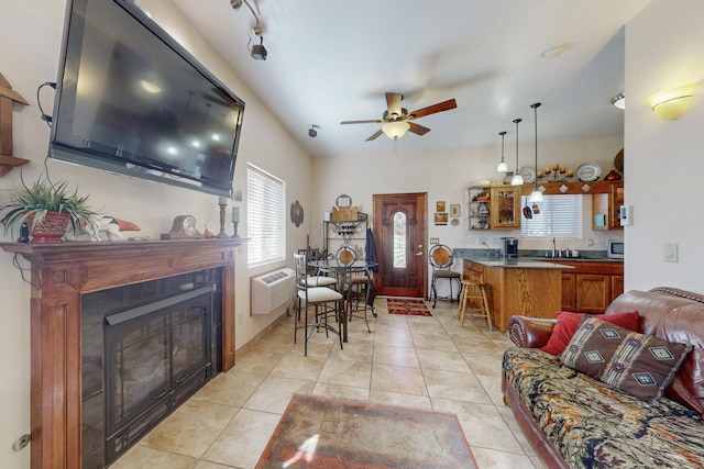 living area with light tile patterned floors, ceiling fan, a wall mounted AC, and a tile fireplace