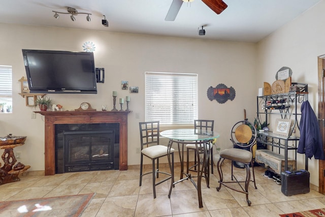 dining area with plenty of natural light, ceiling fan, tile patterned flooring, and a glass covered fireplace